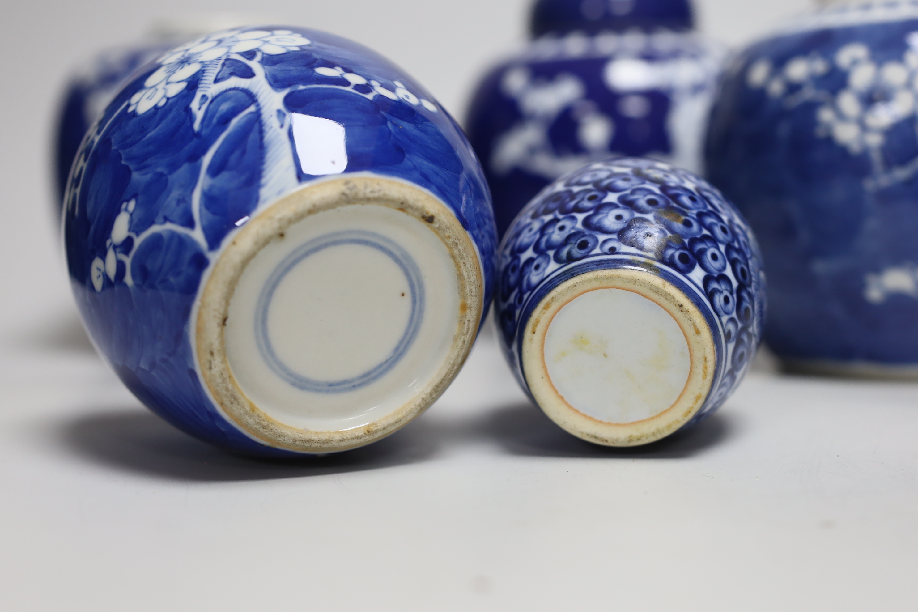 Five Chinese blue and white prunus ginger jars, one with cover- 15cm high and another jar